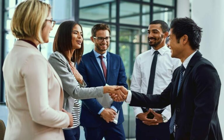 Business people in a group shaking hands